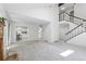 Open living space with staircase, carpet, and view into the kitchen area at 3274 S Heather Gardens Way, Aurora, CO 80014