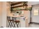 View of kitchen featuring bar seating, wooden shelving, updated green cabinets, and white refrigerator at 9467 W Ontario Dr, Littleton, CO 80128