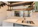 Bright kitchen featuring stone countertop, stainless steel faucet and fixture, and wooden shelving at 9467 W Ontario Dr, Littleton, CO 80128
