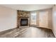 Cozy living room with stone fireplace, large window, and neutral paint at 9467 W Ontario Dr, Littleton, CO 80128