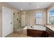 Elegant bathroom featuring a glass-enclosed shower, soaking tub, and stylish fixtures at 228 Horizon Ave, Erie, CO 80516