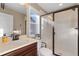Bright bathroom featuring a glass enclosed shower with built-in seat, and a vanity with natural light at 228 Horizon Ave, Erie, CO 80516