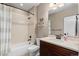 Full bathroom with a shower-tub combo, and vanity with neutral walls and a white door at 228 Horizon Ave, Erie, CO 80516