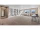 Expansive bonus room featuring custom built-in shelving, plush carpeting, and abundant natural light from multiple windows at 228 Horizon Ave, Erie, CO 80516