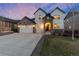 Charming two-story home featuring a three-car garage and a welcoming stone-accented entrance at dusk at 228 Horizon Ave, Erie, CO 80516