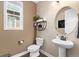 Charming half-bathroom features stylish fixtures, a pedestal sink, and warm, inviting decor at 228 Horizon Ave, Erie, CO 80516