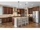 Gourmet kitchen with dark cabinetry, stainless steel appliances, and a center island with seating at 228 Horizon Ave, Erie, CO 80516