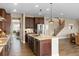 Bright living space with open floor plan, featuring kitchen island, staircase, and dining area at 228 Horizon Ave, Erie, CO 80516