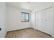 Cozy bedroom featuring wood-look floors, a window, and ample closet space at 2633 Mather St, Brighton, CO 80601