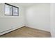 Bright bedroom featuring wood-look floors, a window, and neutral walls for customization at 2633 Mather St, Brighton, CO 80601