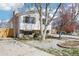 Charming two-story home with a brick chimney, white siding, and a lovely landscaped front yard at 2633 Mather St, Brighton, CO 80601