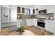 Modern kitchen featuring stainless steel appliances, white cabinetry, and a dining area at 2633 Mather St, Brighton, CO 80601