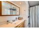 Bathroom featuring a vanity, sink, mirror, lighting, and shower with striped curtain at 8633 E Monmouth Pl, Denver, CO 80237