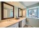 Bathroom with double sinks, vanities, and medicine cabinets, with natural lighting and views outside at 8633 E Monmouth Pl, Denver, CO 80237