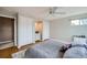 Bedroom with hard wood floors, white trim, a ceiling fan and three closets at 8633 E Monmouth Pl, Denver, CO 80237
