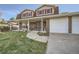 Close up front exterior of a home featuring a porch, garage, and manicured front lawn at 8633 E Monmouth Pl, Denver, CO 80237