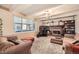 Spacious living room with a brick fireplace, plush carpeting, and large windows at 8633 E Monmouth Pl, Denver, CO 80237