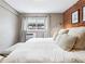 Cozy bedroom with a brick accent wall and white linens, creating a comfortable and inviting space at 160 Jackson St # 5, Denver, CO 80206