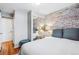 Stylish bedroom featuring a mirrored closet and an exposed brick wall, combining modern and rustic elements at 160 Jackson St # 5, Denver, CO 80206