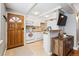 Cozy kitchen featuring white appliances, cabinets, and a breakfast bar with an eye-catching wooden front door at 160 Jackson St # 5, Denver, CO 80206