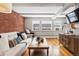 Inviting living room featuring a brick accent wall, hardwood floors, and a comfortable white sofa at 160 Jackson St # 5, Denver, CO 80206