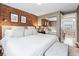 Main bedroom boasts a brick accent wall and a mirrored closet in a home with hardwood flooring at 160 Jackson St # 5, Denver, CO 80206