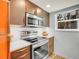 Modern kitchen with stainless steel appliances, wood-tone cabinets, and white countertops at 8378 S Upham Way # A102, Littleton, CO 80128