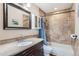Tiled bathroom with a shower-tub combo, vanity with countertop, and a decorative mirror at 21367 E Aberdeen Dr, Centennial, CO 80015