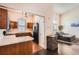Open kitchen with a breakfast bar and a view of the naturally lit living room at 21367 E Aberdeen Dr, Centennial, CO 80015
