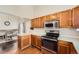 Well-lit kitchen featuring stainless steel appliances, ample countertop space, and wooden cabinets at 21367 E Aberdeen Dr, Centennial, CO 80015