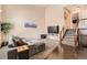 Inviting living room with a high ceiling, cozy seating, and stairs with wooden railing at 21367 E Aberdeen Dr, Centennial, CO 80015