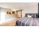 Bedroom featuring carpet, a large bed, and access to a closet and hallway at 2459 S Xanadu Way # B, Aurora, CO 80014