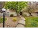 Charming townhouse exterior with landscaped front entrance, gravel and concrete pathway and decorative lamppost at 2459 S Xanadu Way # B, Aurora, CO 80014
