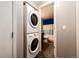 Convenient laundry area with a stacked washer and dryer unit, adjacent to the bathroom at 2459 S Xanadu Way # B, Aurora, CO 80014