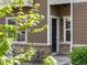 Close up of townhome entry with stone accents and a well-lit porch area at 1456 Sepia Ave, Longmont, CO 80501