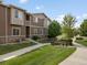 A two-story townhouse with a manicured lawn and pedestrian sidewalk at 1456 Sepia Ave, Longmont, CO 80501