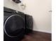This laundry room features modern, front-loading washer and dryer units with dark, luxury vinyl plank flooring at 1456 Sepia Ave, Longmont, CO 80501