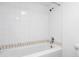 Clean white tiled bathtub and shower combination in a well-lit bathroom at 350 Detroit St # 107, Denver, CO 80206