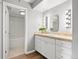 Bright bathroom with white cabinets, tiled countertop, and vanity lighting at 350 Detroit St # 107, Denver, CO 80206