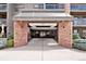 The condo building entrance has a glass awning, brick pillars, and a well-lit entryway for welcoming residents and visitors at 350 Detroit St # 107, Denver, CO 80206
