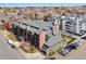 Aerial view of a well-maintained apartment building with ample parking and mature trees at 350 Detroit St # 107, Denver, CO 80206
