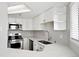 Clean and modern kitchen with white cabinets, stainless steel appliances, and quartz countertops at 350 Detroit St # 107, Denver, CO 80206