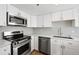 A modern kitchen features white cabinets, stainless steel appliances, and a sink with a countertop perfect for meal prep at 350 Detroit St # 107, Denver, CO 80206