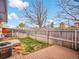 Small backyard with grass, wood fence, deck, and central air unit at 4201 Shoshone St, Denver, CO 80211