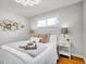 Bright bedroom features two bedside tables, hardwood floors, and neutral decor at 4201 Shoshone St, Denver, CO 80211