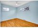 Bedroom with a ceiling fan, hardwood floors, light blue paint, and two windows at 4201 Shoshone St, Denver, CO 80211