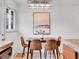 Dining space with a view of the kitchen and dining room, complemented by natural light and an artful chandelier at 4201 Shoshone St, Denver, CO 80211