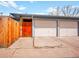 Two-car garage with concrete driveway, wood gate, and white doors at 4201 Shoshone St, Denver, CO 80211
