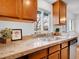 This kitchen features stone countertops, wood cabinetry, and a stainless steel sink at 4201 Shoshone St, Denver, CO 80211