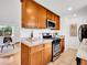 Modern kitchen with stainless steel appliances, granite countertops, and natural wood cabinetry at 4201 Shoshone St, Denver, CO 80211